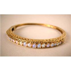 A 14K YELLOW GOLD BANGLE BRACELET With twenty-two round opal cabochons, apx. weight 9.50 dwt, missin