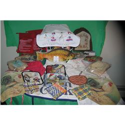 Box of cooking aprons, hot plate mats and more