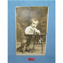 Early photo post card featuring a young boy with toys