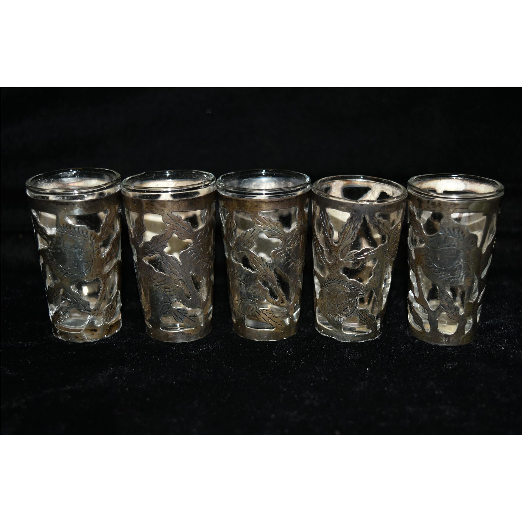 Five decorated sterling silver shot glasses with glass