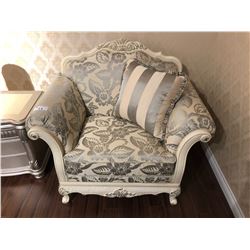 OVER SIZED LOUNGE CHAIR WITH FLORAL PRINT AND WOOD TRIM.