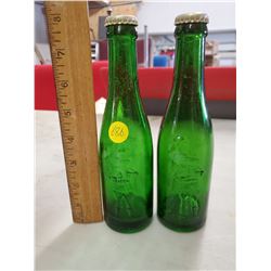 TWO EMBOSSED GREEN SODA BOTTLES (MOUNTIES)