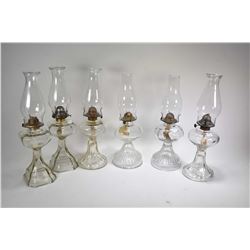 Three pairs of colourless oil lamps, all with hurricanes