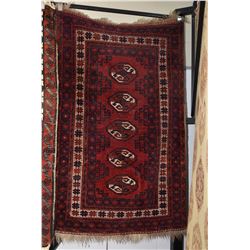 Iranian wool throw rug with multiple medallions, deep red background and highlights in copper, white