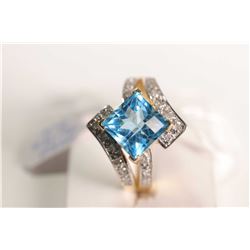 New old stock 14kt yellow gold, topaz and diamond ring. Set with 3.50ct square checkerboard cut blue