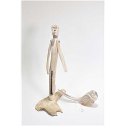 Carved bone articulated sculpture of a male figure 12 1/2" in height and a carved bone bird signed b