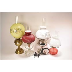 Four vintage oil lamps including brass with transfer ware floral shade and hurricane. nickel plated