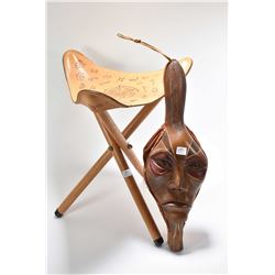 Folk art carved face bellows signed by artist and a three legged tooled leather stool from The Weste