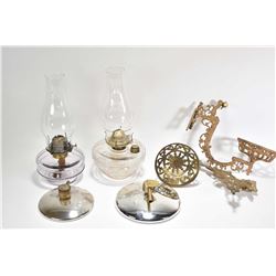 Two wall mount colourless oil lamps including brackets and reflectors, note one turning purple