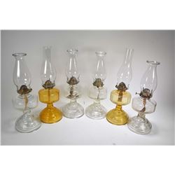 Three pairs of vintage glass oil lamps including two pairs of colourless and a pair of amber glass l