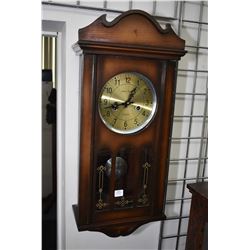 Semi contemporary vintage style wall clock in wood case with brass dial, visible pendulum and 15 day