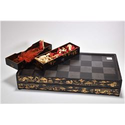 Antique Chinese lacquered game board/box includes thirty two ivory chess pieces, a few with some dis