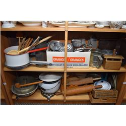 Two shelves of collectibles of primitive kitchenware including enamel, butter pats, rolling pins, bo