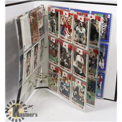 SMALL BLACK BINDER WITH ASSORTED SPORTS CARDS.