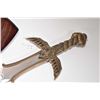 Image 2 : Two decorative broad swords each with serpentine and figural hilt and each with wooden wall mount ha