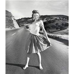 ANDRE DE DIENES (1913-1985): MARILYN MONROE on road side in 1945.
