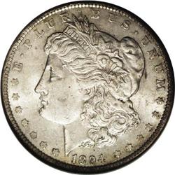 1894 S$1 AU58 NGC. Subdued silver surfaces with pale g