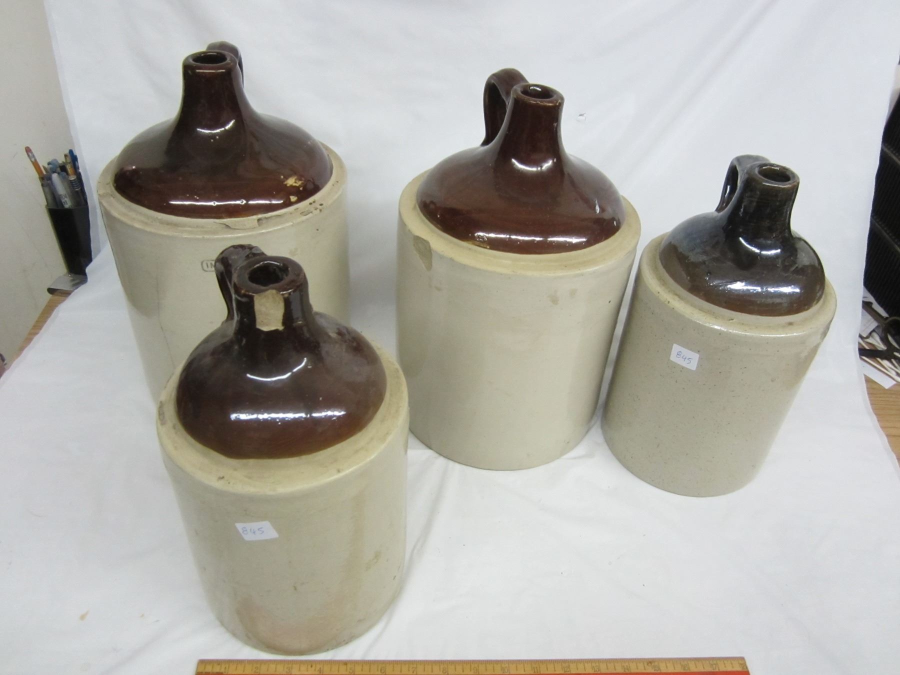 Lot of 4 stoneware jugs 1 and 2 gal chips and cracks 1 good