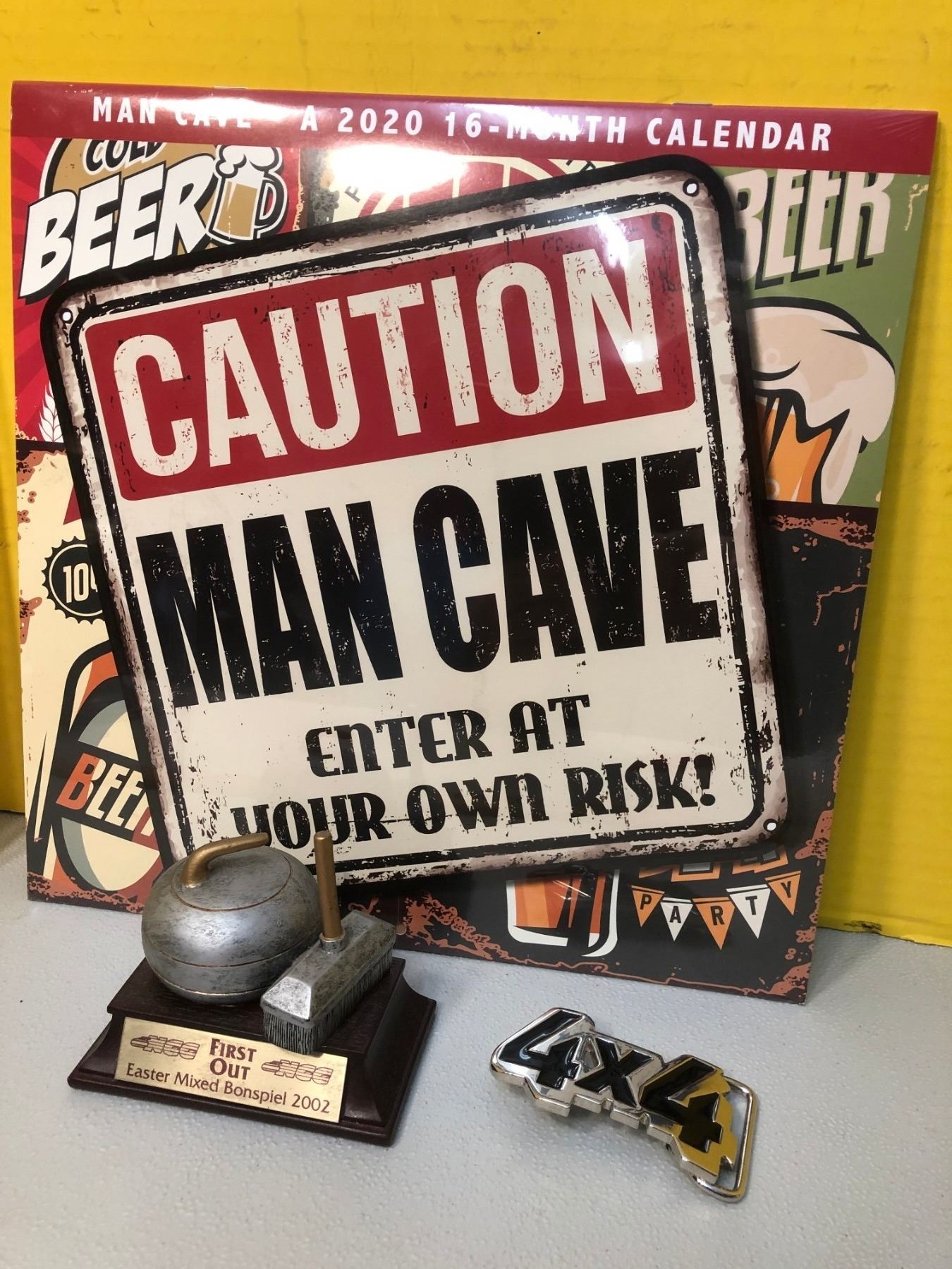 MAN CAVE CALENDAR AND FIRST OUT 2002 BONSPIEL TROPHY Schmalz Auctions