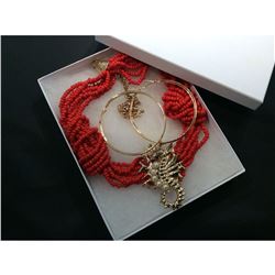 Red fabric designer necklace with golden seahorse motif.