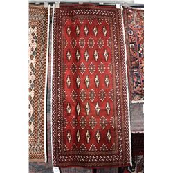 100% handmade scatter rug with red background and highlights of brown, cream and blue, 23" x 53"