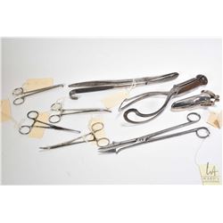 Selection of vintage medical equipment including spiked forceps, locking forceps, a speculum, large 