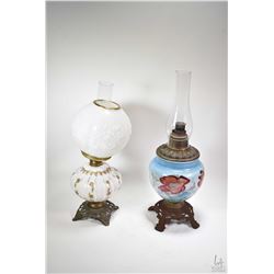 Two banquet style oil lamps including cast base with handpainted fonts, one with globe and both with