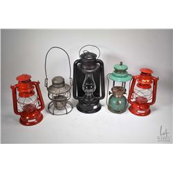 Five vintage metal lanterns including G.N. RWy railway lamp, three barn lamps and a Coleman pressure