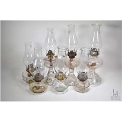 Seven colourless oil lamps, various styles and sizes