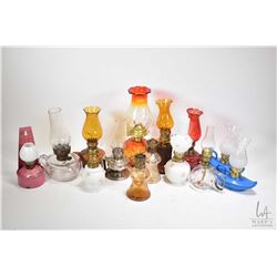 Selection of miniature oil lamps, various sizes and shapes including coloured glass etc.