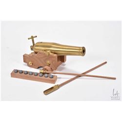 Two miniature brass cannons on wooden with wooden carts, cannon balls and tamper rods etc. largest w