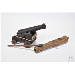 Two miniature cannons including 8" brass cannon sans cart and a 6" cannon on a wooden cart with a ta