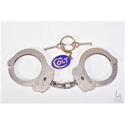 Pair of vintage genuine Colt Firearms handcuffs, serial no. 008194 with two keys and a Colt keychain