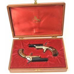 Cased pair of Colt Derringers, #73590D and 73591D, .22 short cal., 2 3/8” barrels, black with gold