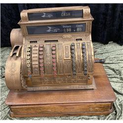 Fancy Brass cash register. $99.99 highest denomination. Measures 22 1/2" by 25" wide by 16" deep.