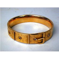 A 14K YELLOW GOLD BUCKLE FORM BANGLE BR