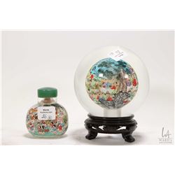 Two pieces of Chinese reverse painted glass including 5" glass ball on wooden plinth and a 2 3/4" sn