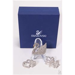 Three Swarovski crystal brooches including swan, three leaf brooch and a double heart brooch