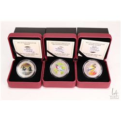 Three Royal Canadian Mint cased coloured coins including 2012 Rose-breasted Grosbeak 25 cent coin, 2