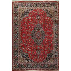 A WOOL HAND KNOTTED FLORAL MEDALLION AREA RUG.