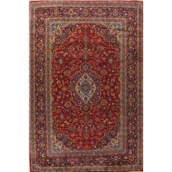 A WOOL HAND KNOTTED FLORAL MEDALLION AREA RUG.