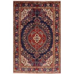 A WOOL HAND KNOTTED FLORAL MEDALLION AREA RUG.