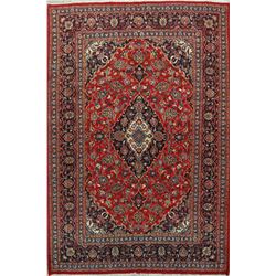 A WOOL HAND KNOTTED FLORAL MEDALLION AREA RUG.