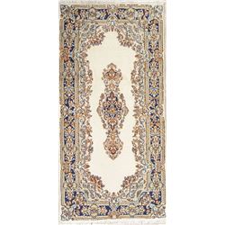 A WOOL HAND KNOTTED FLORAL MEDALLION AREA RUG.