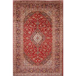 A WOOL HAND KNOTTED FLORAL AREA RUG.