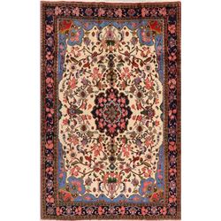 A WOOL HAND KNOTTED FLORAL MEDALLION AREA RUG.