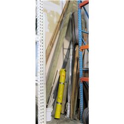 Mixed lot corner of warehouse.   2x3 pieces of wood, 2x12 wood, large roll of carpet, large roll of 