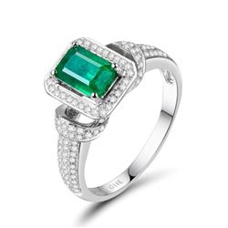 A 14KT WHITE GOLD AND EMERALD & DIAMONDS RING.