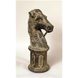 A CAST IRON HORSE HEAD HITCHING POST