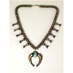 AN OLD NAVAJO HAND WROUGHT SILVER AND TURQUOISE SQUASH BLOSSOM NECKLACE